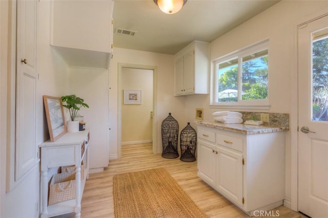 kitchen with white cabinets and light hardwood / wood-style flooring