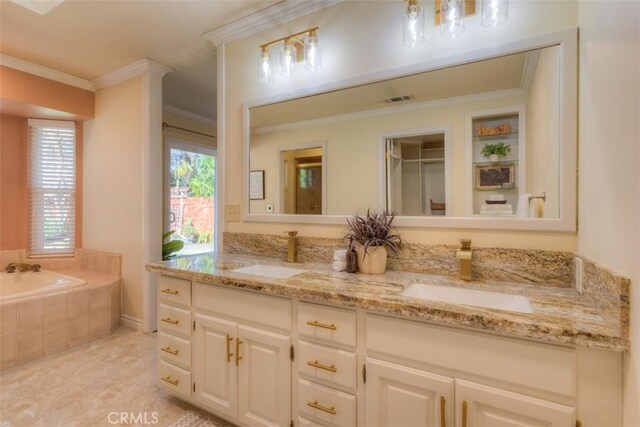 bathroom featuring crown molding, tiled bath, vanity, and tile patterned floors