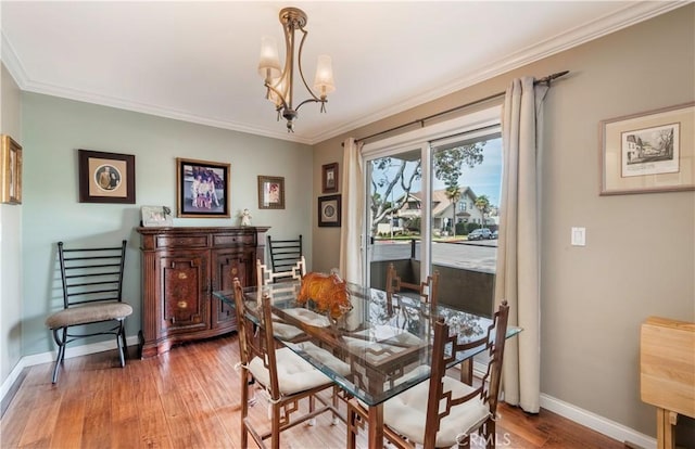 dining area with crown molding, hardwood / wood-style flooring, and a chandelier