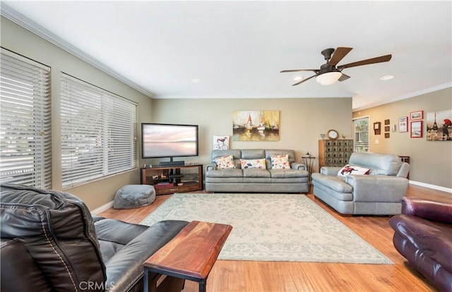 living room featuring hardwood / wood-style flooring, ceiling fan, and ornamental molding