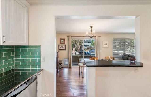 kitchen featuring pendant lighting, dishwasher, white cabinetry, ornamental molding, and kitchen peninsula