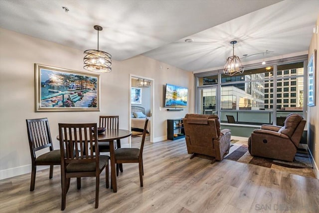 dining room with wood-type flooring and a notable chandelier