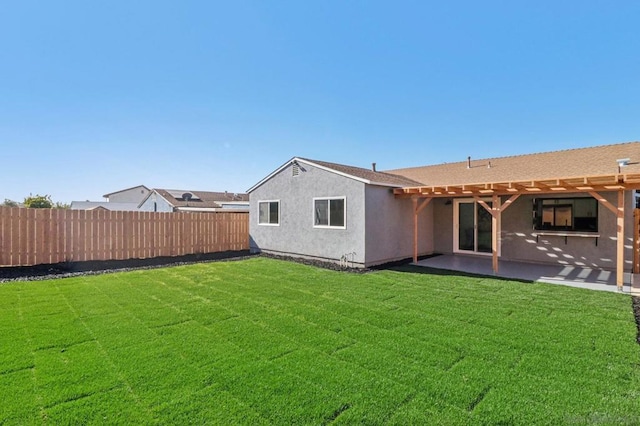 back of house featuring a lawn and a patio area