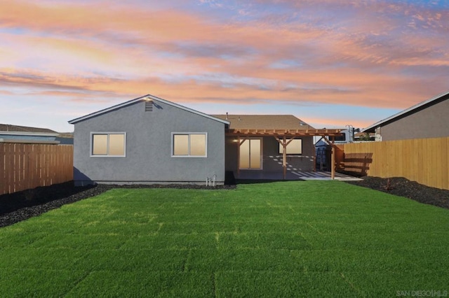 back house at dusk featuring a yard