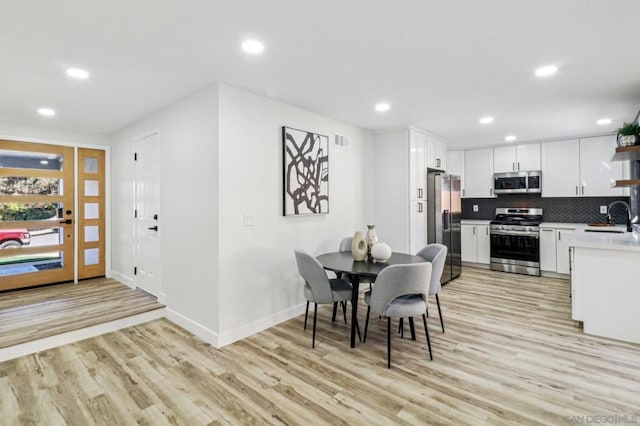 dining area with sink and light hardwood / wood-style flooring