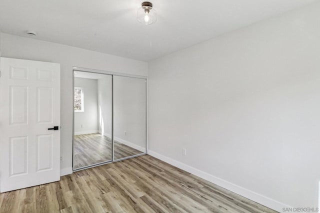 unfurnished bedroom featuring light hardwood / wood-style floors and a closet