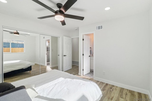 bedroom featuring ceiling fan, light hardwood / wood-style flooring, and a closet