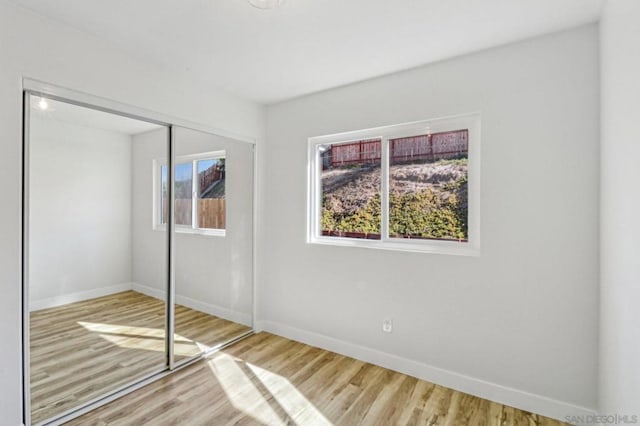 unfurnished bedroom with a closet and hardwood / wood-style floors