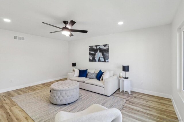 living room featuring ceiling fan and hardwood / wood-style flooring