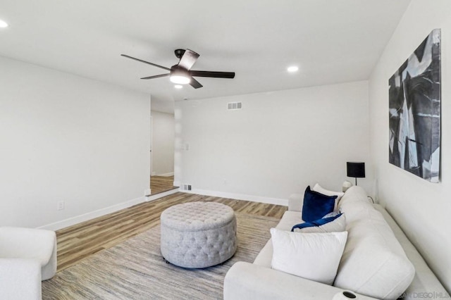 living area featuring hardwood / wood-style floors and ceiling fan