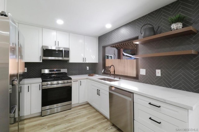 kitchen with sink, white cabinetry, tasteful backsplash, and appliances with stainless steel finishes