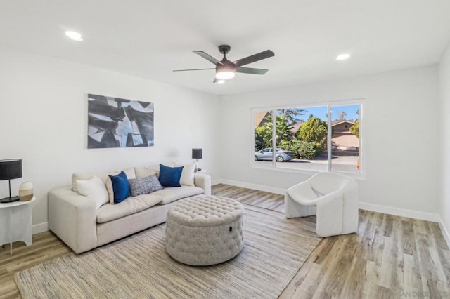 living room with light wood-type flooring and ceiling fan