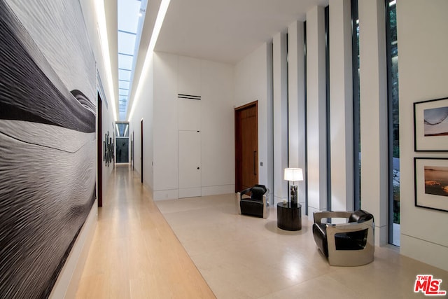 hallway with a high ceiling and hardwood / wood-style floors