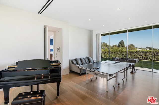 recreation room with a wall of windows and hardwood / wood-style floors