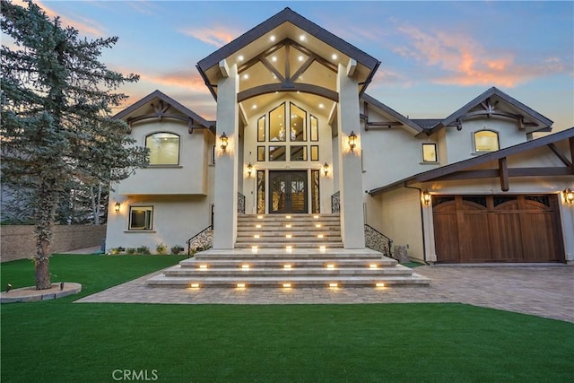 view of front of home with a lawn, french doors, and a garage