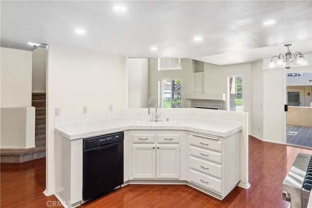 kitchen featuring tile countertops, black dishwasher, white cabinets, and wood finished floors