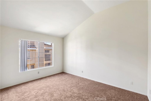 carpeted empty room with lofted ceiling and baseboards