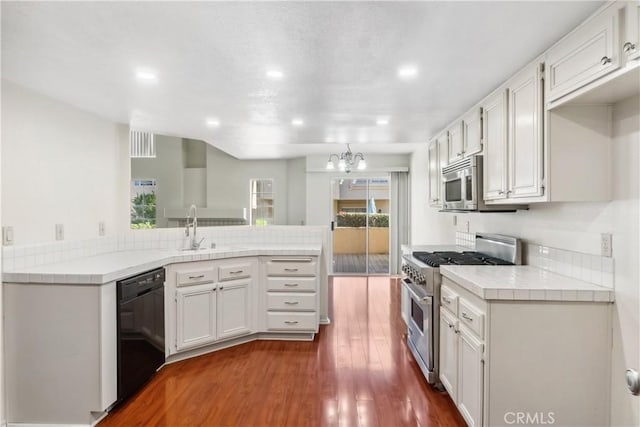 kitchen with stainless steel appliances, an inviting chandelier, dark hardwood / wood-style flooring, and white cabinetry