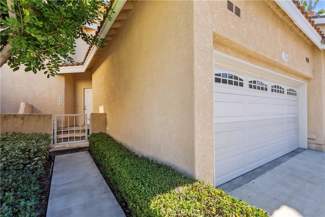 view of side of property with driveway and stucco siding