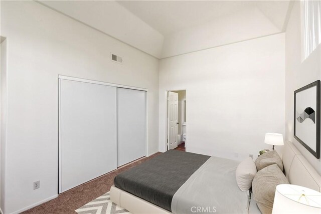 carpeted bedroom with lofted ceiling and a closet