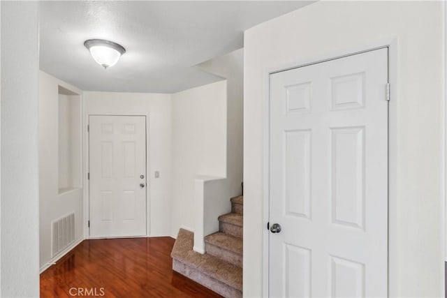 foyer featuring stairs, wood finished floors, and visible vents