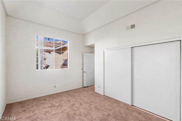 unfurnished bedroom featuring carpet floors, a closet, and visible vents