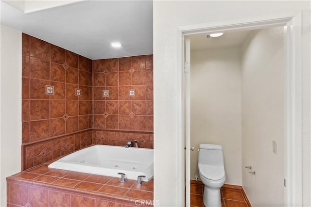 bathroom with toilet, tiled tub, and tile patterned flooring