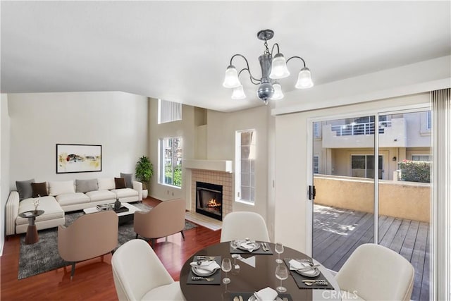 dining room featuring a notable chandelier, hardwood / wood-style floors, and a fireplace