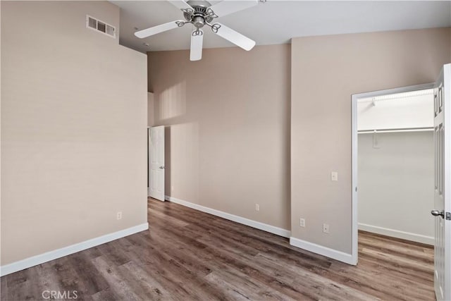 unfurnished bedroom with dark wood-type flooring, ceiling fan, and a closet