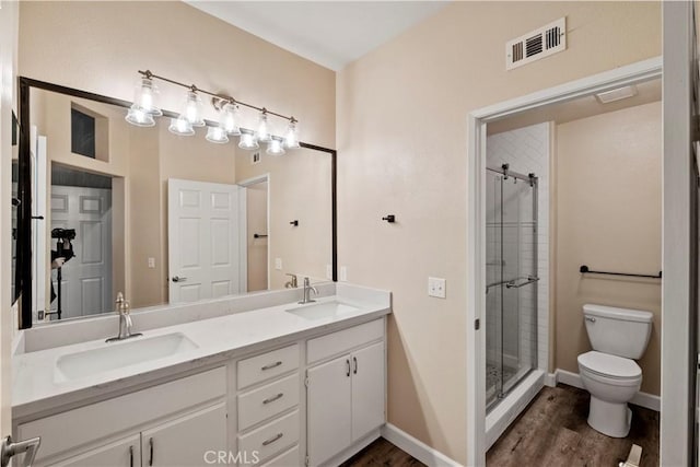 bathroom featuring toilet, wood-type flooring, walk in shower, and vanity