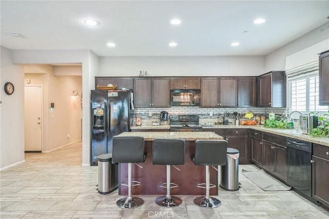 33312 Hitching Post Dr, Winchester, CA 92596 - kitchen featuring black appliances, a sink, tasteful backsplash, dark brown cabinets, and a breakfast bar area