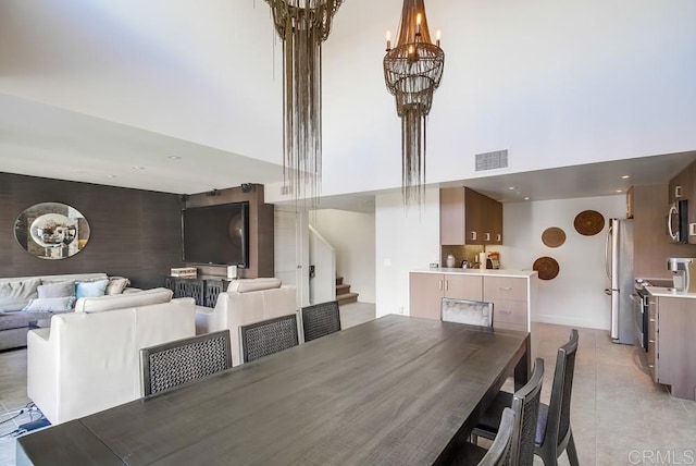 dining room featuring a towering ceiling and a notable chandelier