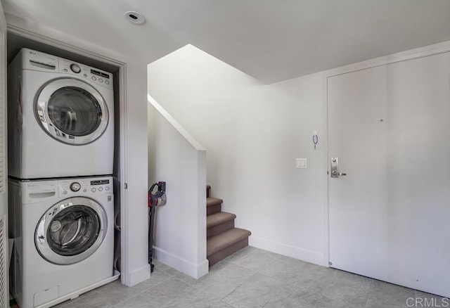 clothes washing area with stacked washer / dryer