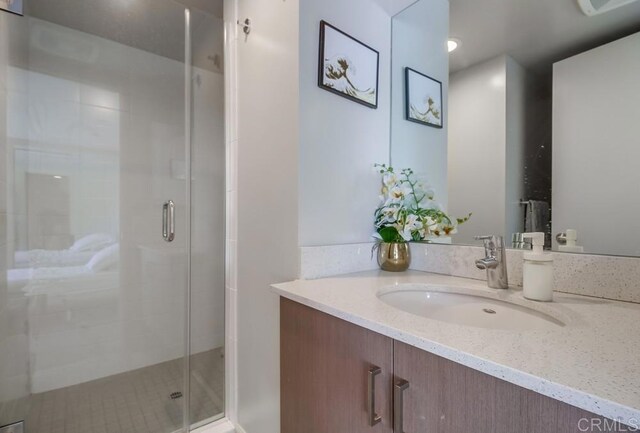 bathroom with vanity and a shower with shower door