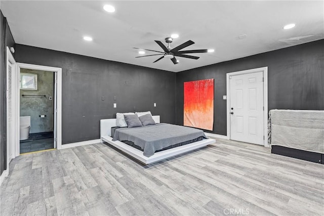 bedroom with ceiling fan, ensuite bathroom, and light hardwood / wood-style floors