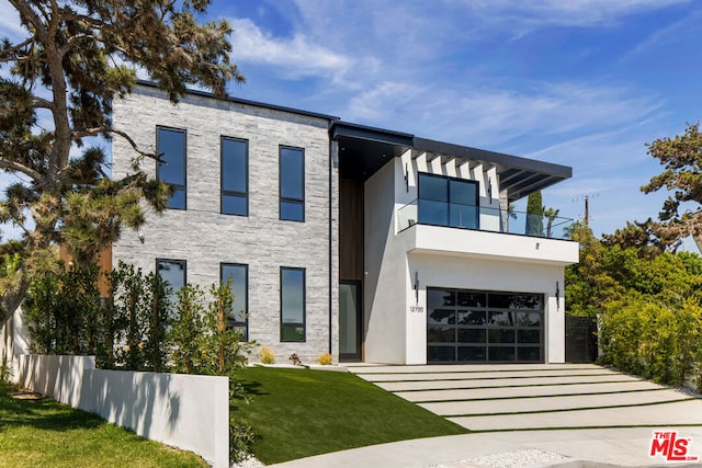 contemporary home with a balcony, a front yard, and a garage