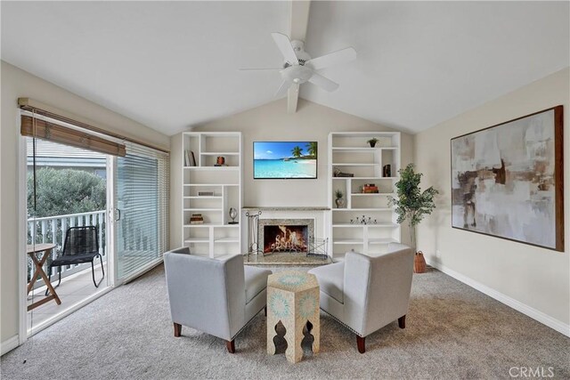 living room with ceiling fan, a high end fireplace, carpet flooring, and vaulted ceiling with beams