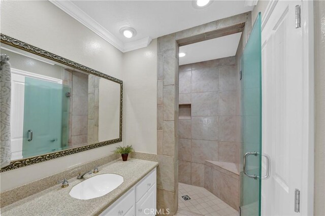 bathroom with a shower with door, crown molding, and vanity