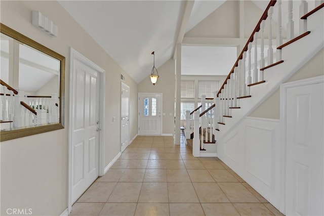 foyer featuring light tile patterned floors and vaulted ceiling