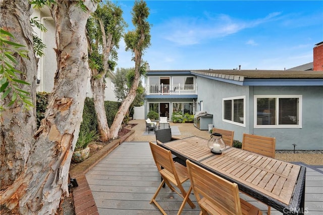 rear view of house featuring a wooden deck and a balcony