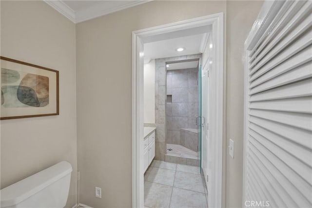 bathroom with a shower with shower door, ornamental molding, vanity, toilet, and tile patterned floors