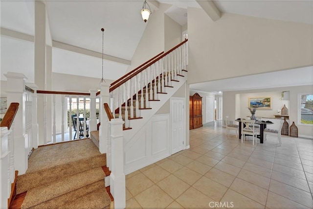 stairs featuring tile patterned flooring, an inviting chandelier, high vaulted ceiling, and beamed ceiling