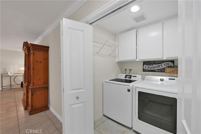 clothes washing area with cabinets, ornamental molding, separate washer and dryer, and light tile patterned floors