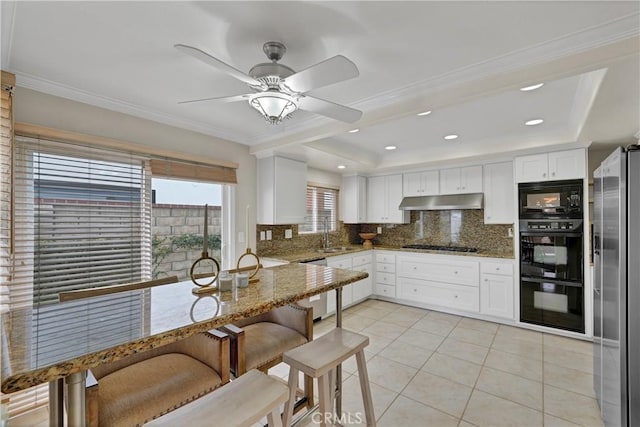 kitchen featuring light stone counters, backsplash, black appliances, and white cabinets