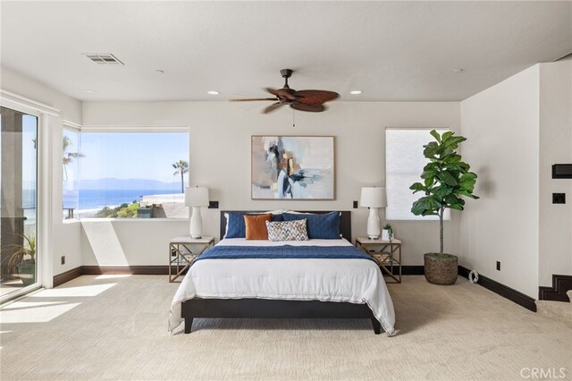 bedroom with a water view, ceiling fan, light carpet, and access to outside