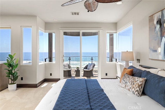 carpeted bedroom with a water view and access to exterior