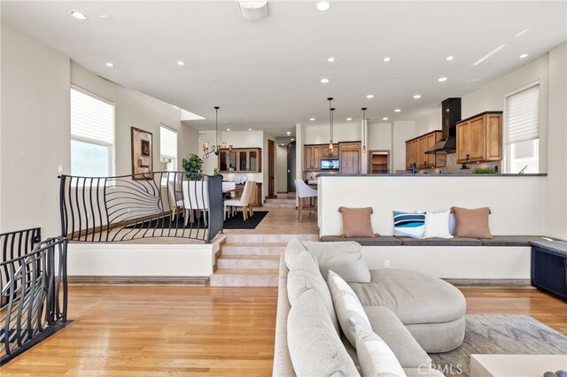 living room featuring a chandelier and light hardwood / wood-style flooring