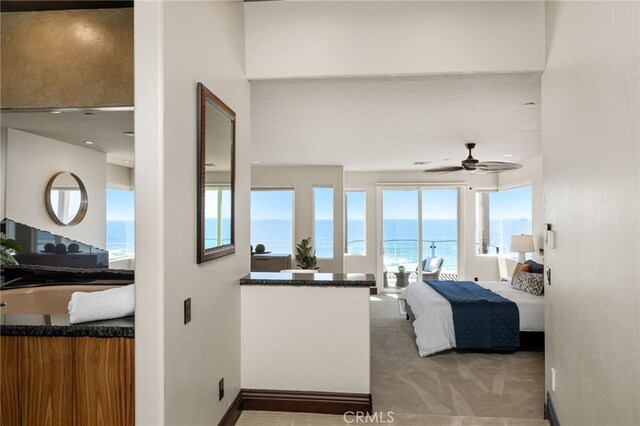 carpeted bedroom with a water view and ceiling fan