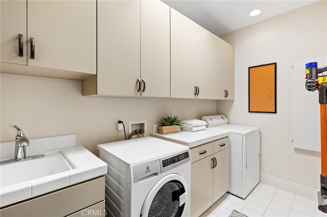 washroom with independent washer and dryer, sink, cabinets, and light tile patterned floors