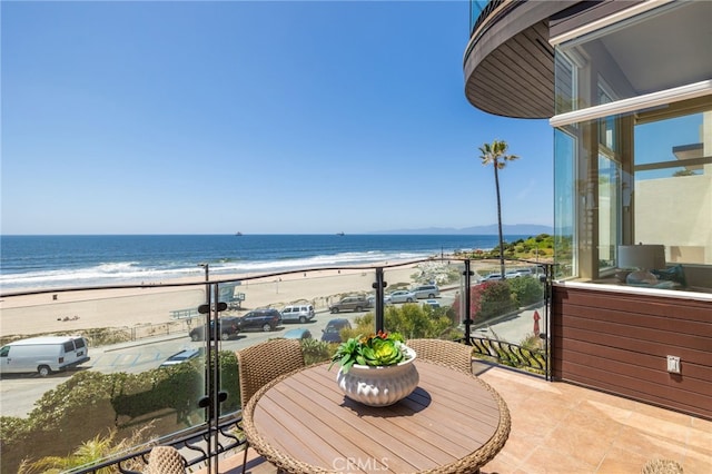 balcony featuring a water view and a beach view